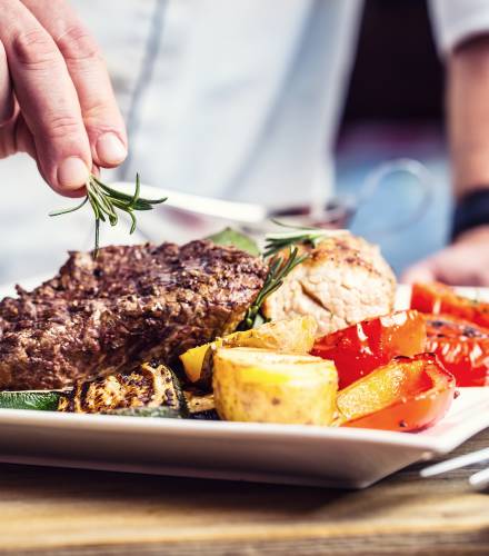 Fleisch und Gemüse werden auf einem Teller angerichtet